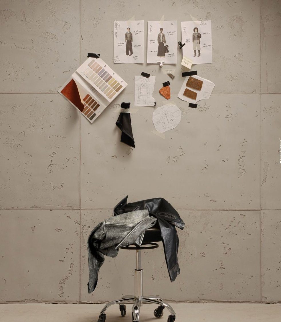 Studio mood-board with sketches, fabric swatches, and leather jacket